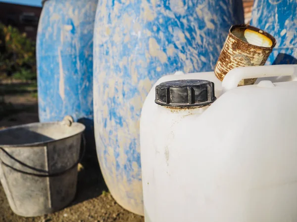 Beyaz can ve mavi plastik varil gibi eski inşaat ekipmanları