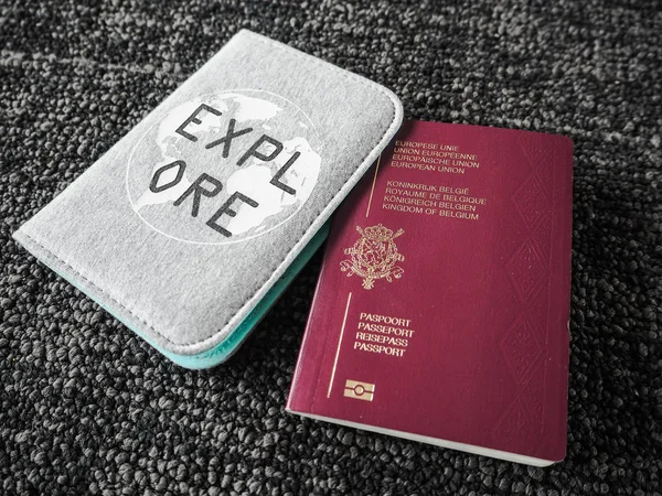 Belgian passport and inspirational passport cover with the quote 'Explore' on a dark background