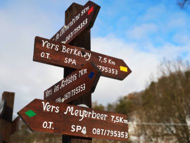 Finger post with directions to multiple walking routes in the area of Spa, Belgium, famous for its mineral springs and racing circuit. clipart