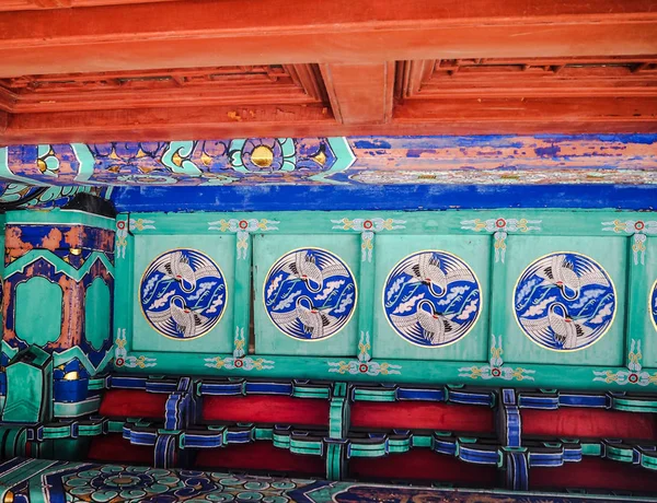Vibrant roof paintings in red and blue with cranes in a Chinese taoist temple