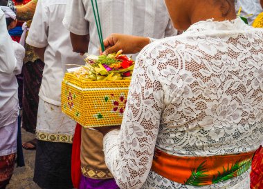 Geleneksel giyim ve Bali dili yeni yıl için Nusa lembongan, Bali, Endonezya elinde bir teklif sepeti tütsü sopa koyarak doğrultusunda bekleyen genç Asyalı kadın giyinmiş