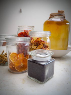 Siyah çay yaprakları ve elma gibi kuru maddeler Kombucha büyük bir kavanoz yanında