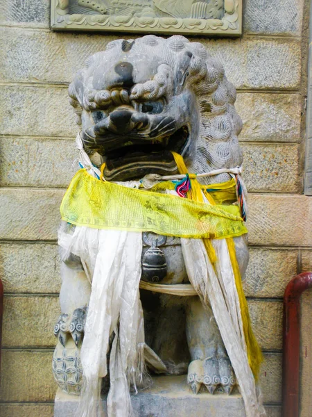 仏教の祈りの旗で覆われた石のライオンガード像 — ストック写真