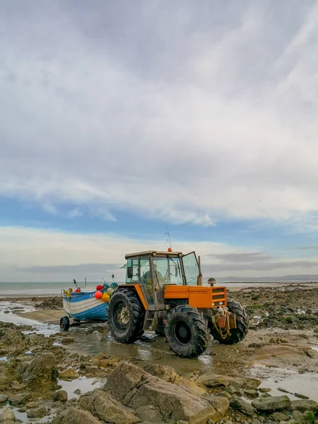 Diciembre 2018 - Wissant, Francia: tractor naranja remolcando un barco de madera —  Fotos de Stock