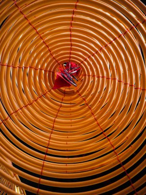 Bir Çin tapınağında tavandan asılı büyük bir sarı tütsü bobini içinde düşük açı görünümü