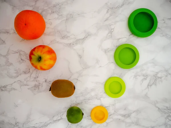 Variedad de frutas y coloridas envolturas de alimentos ecológicos de silicona para preservar los alimentos cortados para un estilo de vida de cero desperdicios —  Fotos de Stock