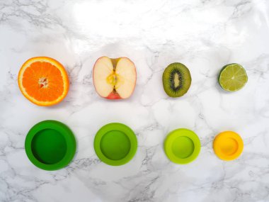 Sıfır atık yaşam tarzında gıda atıklarının azaltılması için çeşitli meyve çeşitleri ve renkli yeniden kullanılabilir silikon gıda paketleri