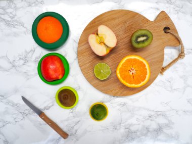 Sıfır atık yaşam tarzında gıda atıklarının ve gıda kaybının azaltılması için yeniden kullanılabilir silikon gıda paketlerinde dilimlenmiş meyveler.