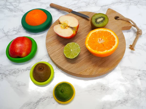 Sliced fruits with colorful reusable silicone food wraps for reducing food waste and food loss in a zero waste lifestyle