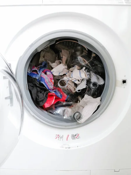 Washing machine filled with plastic waste representing micro plastic waste pollution during laundry