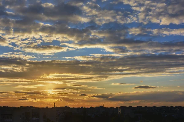 夕方の街のシルエットの建物の上の日没時の空と雲 — ストック写真