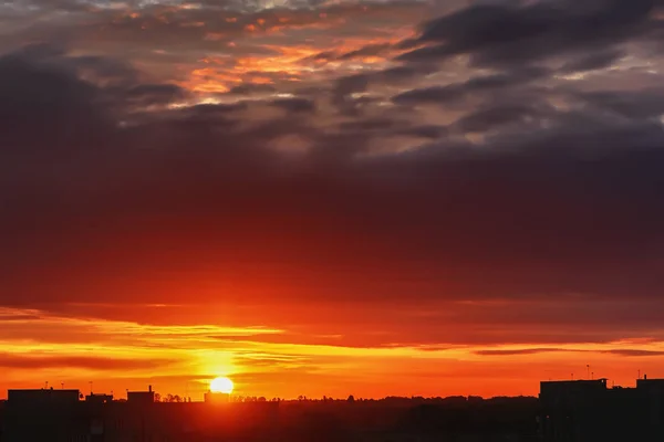 シティ 太陽と雲 家や木のシルエットが付いている空に沈む夕日 — ストック写真