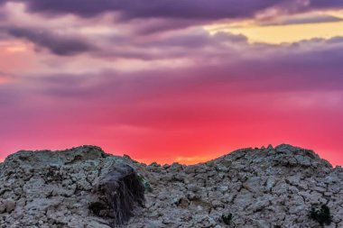 Gökyüzü günbatımı kum tepelerin üzerinden bulutlara ile.