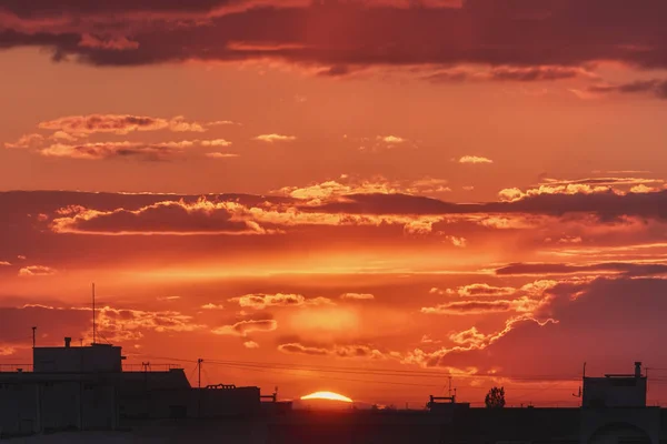 日落时 太阳和天空笼罩在城市屋顶的剪影上 — 图库照片