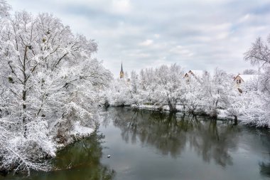 Kış manzarası - karla kaplı ağaçlar ve binalar Nehri kıyısında.