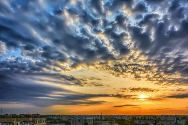 Güneş, gökyüzü bulutlu sabah şehir üzerinde gündoğumu.