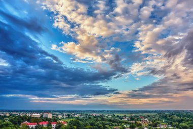 Gökyüzü bulutlu gün batımında akşam şehir üzerinde.
