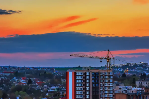 Şehir çatılar, İnşaat vinçleri ve gün batımında yeni binalar.