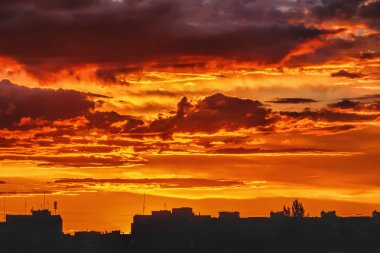 Gün batımında gökyüzü ve bulutlar akşam şehrin siluet binaları üzerinde.