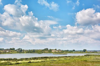 Kırsal manzara - gölet, çayırlar mavi gökyüzü ve bulutlar onlar üzerinde.