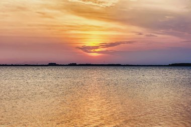 Güzel gün batımı göl üzerinde bir bulutlar suya yansıyan.