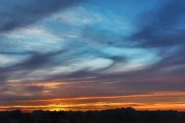 Şehrin çatılarında gün batımı siluetleri.