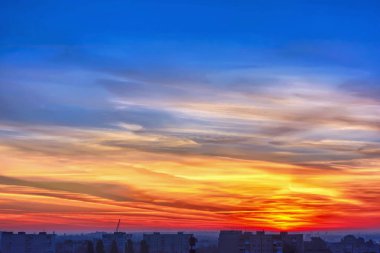 Gökyüzü bulutlu gün batımında şehir binalar üzerinde.