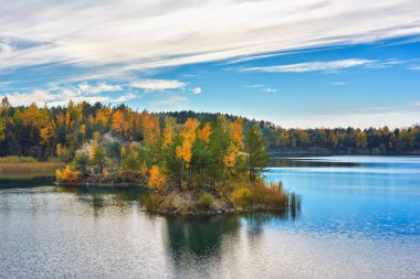 Sonbahar akşam peyzaj - kayalık nerede ağaçların yaprakları sararmış gölün kıyısında.