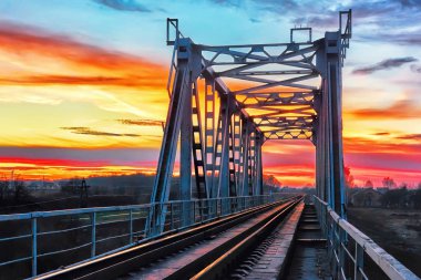 Günbatımı gökyüzüne karşı demiryolu Köprüsü.