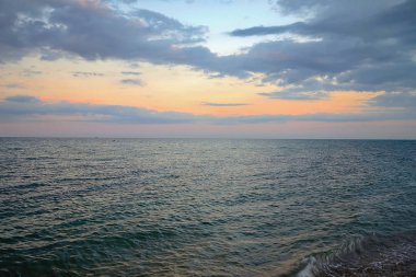 Gökyüzü bulutlu gün batımında denize.