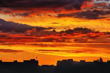 Şehrin çatılarında gün batımı siluetleri.