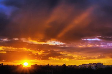 Yağmur, gökyüzü gün batımında bulutlar ile akşam şehir.