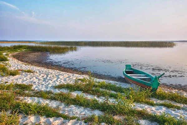 Balıkçı teknesi sahilde gündoğumu göl kenarında.