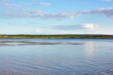 Manzara - nehir, nehir, mavi gökyüzünde bulutlar ve su onun yansıması.