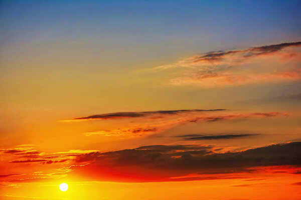 Солнце на восходе солнца с облаками на голубом небе
.