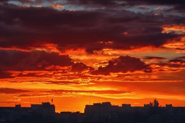 Gün batımında gökyüzü ve bulutlar akşam şehrin siluet binaları üzerinde.