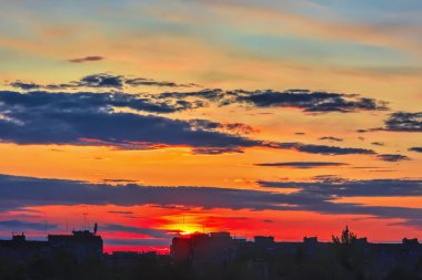 Gökyüzü bulutlu gün batımında şehir binalar üzerinde.