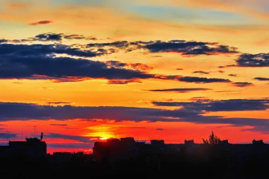 Gökyüzü bulutlu gün batımında şehir binalar üzerinde.