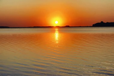 Göl günbatımı. Kıyı boyunca güneş.