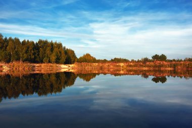 Gece manzara-mavi gökyüzü ve bulutlar ile gölet ve sahil.