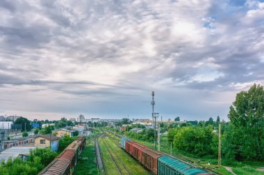 Gün doğumunda elektrikli tren ve yük vagonları olan şehir merkezi..
