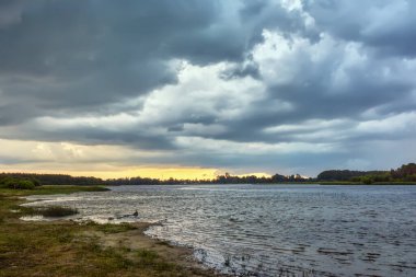 Gün batımında göl üzerinde fırtına.