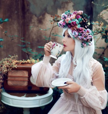 Çiçek çelenk çay bardağı ile güzel kadın