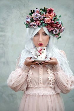 Çiçek çelenk çay bardağı ile güzel kadın