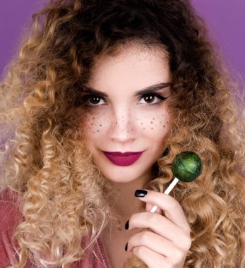 Young woman with freckles and curly hair holding lollipop clipart