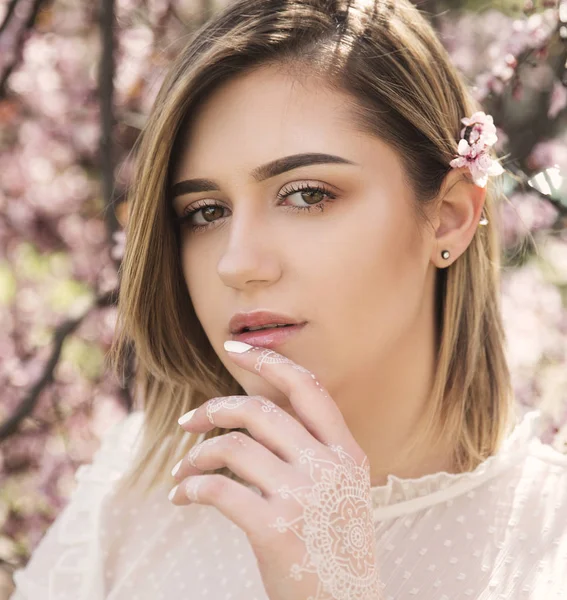 桜の花とポーズの若い女性の肖像画 — ストック写真