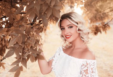 Ağacın duran genç gülümseyen kadın