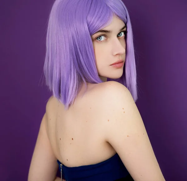 Young woman with purple hair looking at camera