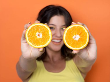 Portakal dilimleriyle poz veren genç bir kadın.