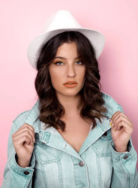 Portrait of young stylish woman on pink background